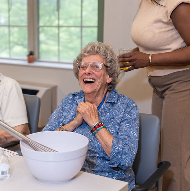 senior laughing with bowl and mixer