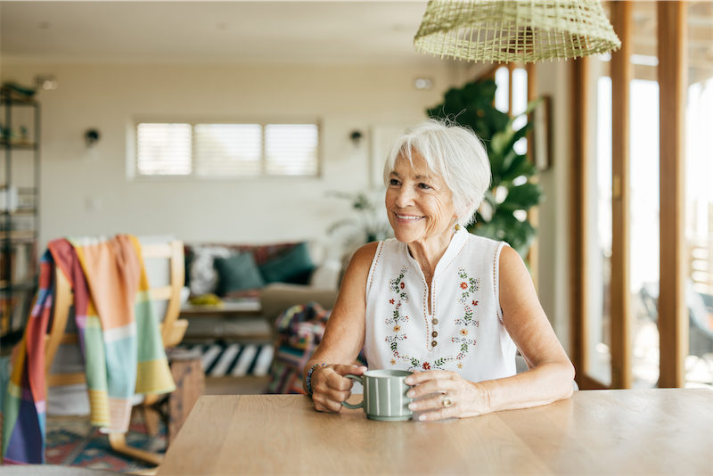 Senior woman sitting at a table with a cup of coffee